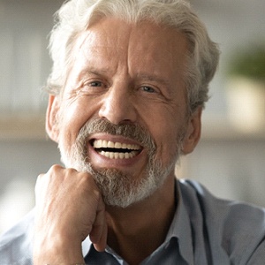 Happy senior man smiling with his dentures in Needham