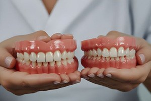 Dental team member holding two denture models