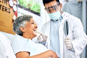 Happy dental patient looking in mirror