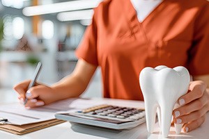 Dental team member sitting at desk, working on paperwork