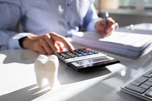 Dentist calculating dental insurance coverage