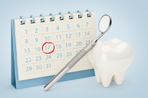 Tooth model and dental mirror in front of calendar