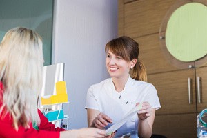 Dental team member reviewing paperwork with patient