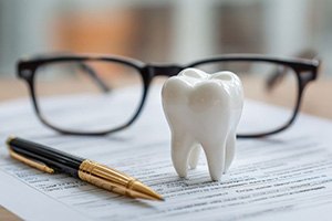 Document with pen and tooth model