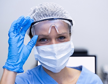 Dental team member wearing gloves face mask and safety goggles