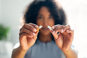 Woman breaking a cigarette in half