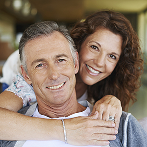 Man and woman smiling after emergency dentistry