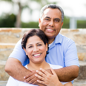 Man and woman smiling after tooth extractions