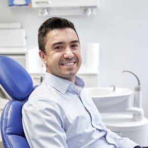 Male patient smiling after dental implant failure and salvage in Needham