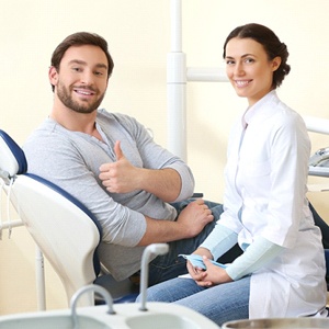 Patient giving thumbs up for full mouth reconstruction in Needham