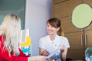 Patient and dental team member discussing cost of full mouth reconstruction