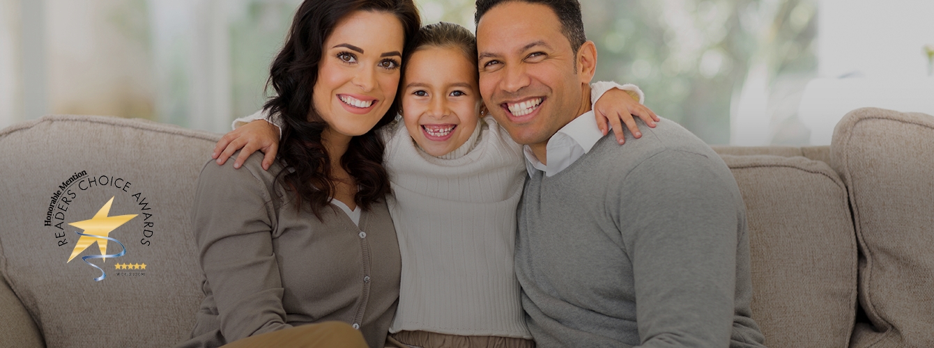 Mother father and child smiling on a couch