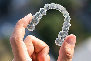 Hand holding invisalign tray