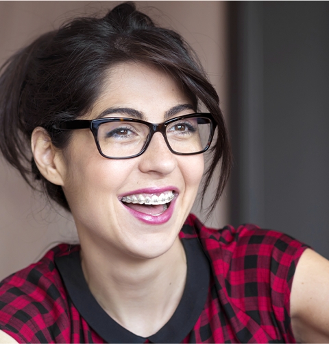 Woman with glasses and braces smiling