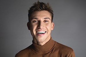 Handsome, smiling man with white teeth, wearing brown sweater