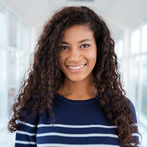 Teen girl smiling at camera after wisdom tooth extractions