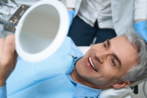 Patient admiring his new smile after All-on-4 recovery in Needham