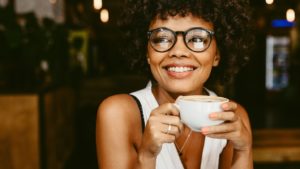 Woman with Invisalign in Needham enjoying a cup of coffee