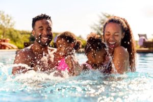 Happy family splashing around in pool