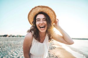 Woman on beach, grinning happily