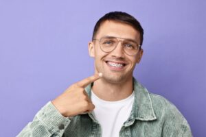 Adult man pointing at his dental braces 