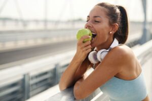 Woman eating an apple after her workout 